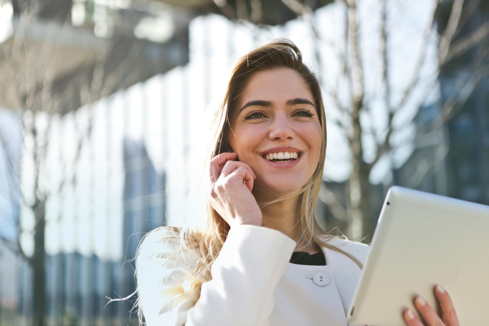 Frau die Telefoniert und ein Laptop in der Hand hält Frau die Telefoniert und ein Laptop in der Hand hält